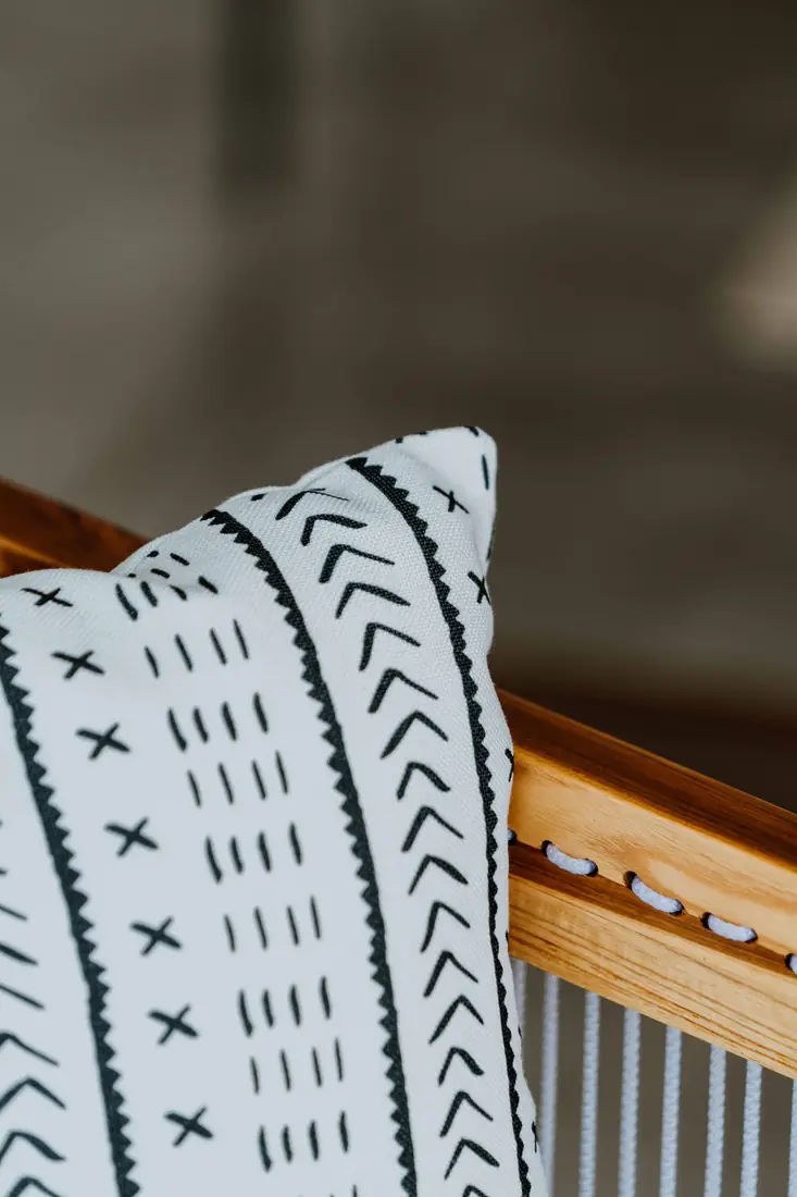 Coussin en bogolan noir et blanc posé sur une chaise en bois