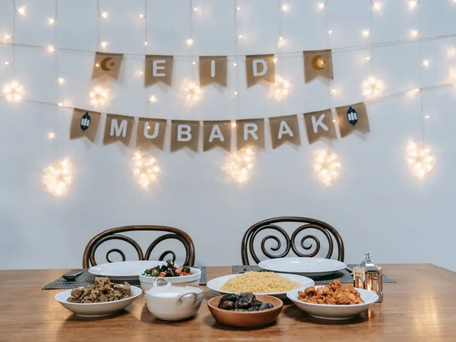 Table de fête dressée sous une guirlande lumineuse et une banderole de fête